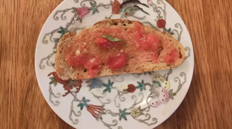 Tomate du jardin épluchée et écrasée sur du pain au petit épeautre préalablement frotté à l'ail: un régal.